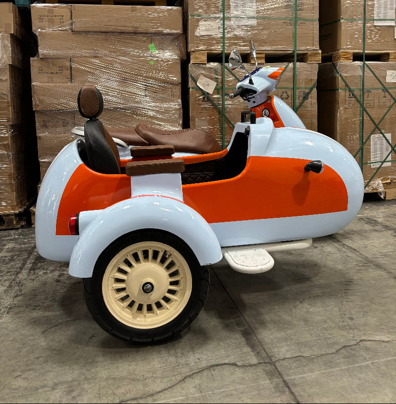 Small orange and white vehicle on a warehouse floor with stacked pallets in the background