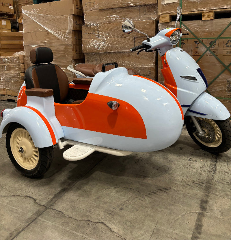 White and orange and white Supermach MP200 M3 Retro sidecar scooter leaning against a stack of cardboard boxes on a concrete floor.