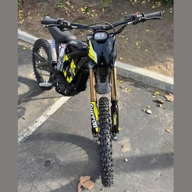 Front view of black Skytour electric dirt bike with yellow graphics and gold forks