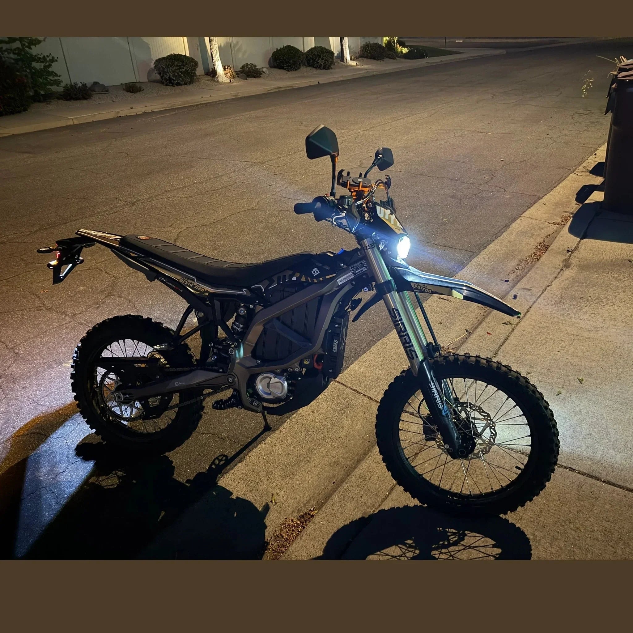 Surron Ultra Bee R electric dirt bike at night with headlight illuminated