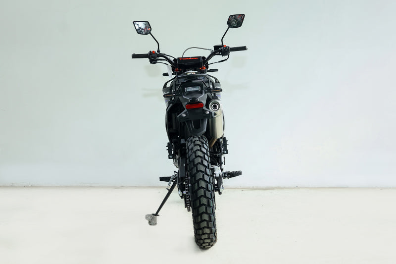 Rear view of black TrailMaster RMX250 showing tall knobby tire and chrome exhaust