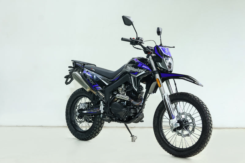 Purple and black TrailMaster RMX250 dual sport motorcycle side view on white background