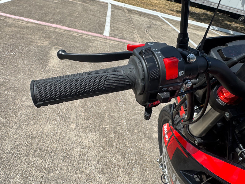 TrailMaster RMX250 handlebar close-up with textured grip, brake lever, and LED control module