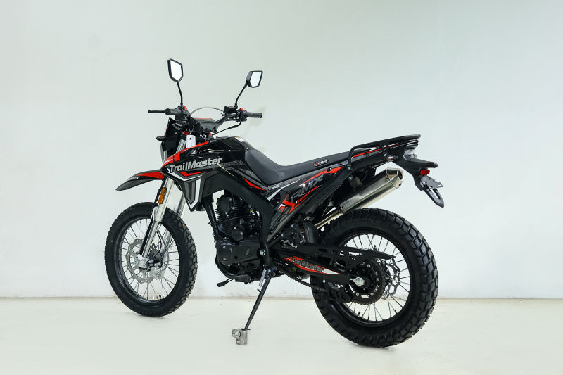 Black and red TrailMaster RMX250 side profile with exposed engine and spoked wheels