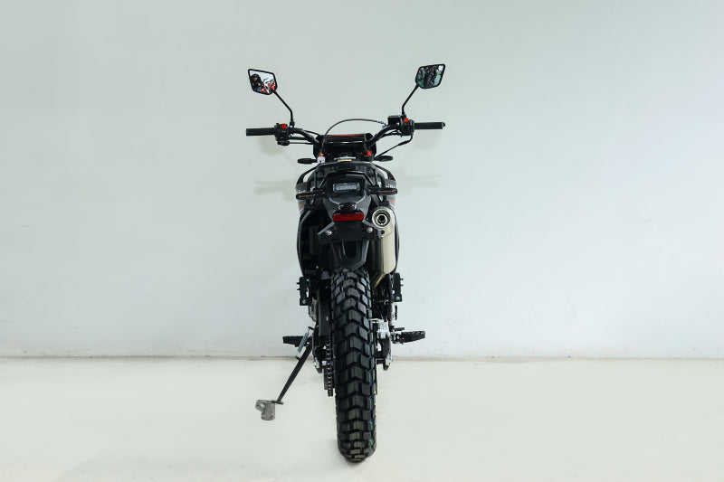 Rear view of black TrailMaster RMX250 featuring silver exhaust and knobby rear tire