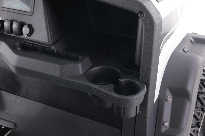 Black plastic cup holders and dashboard storage compartment in a utility vehicle with rugged tires