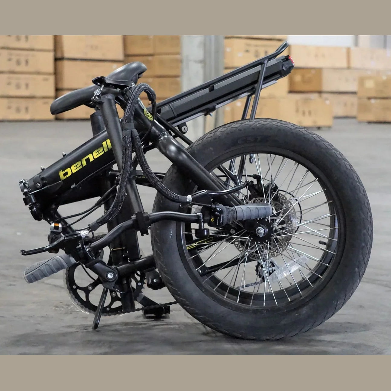 Partially folded black Benelli e-bike in warehouse with handlebars secured