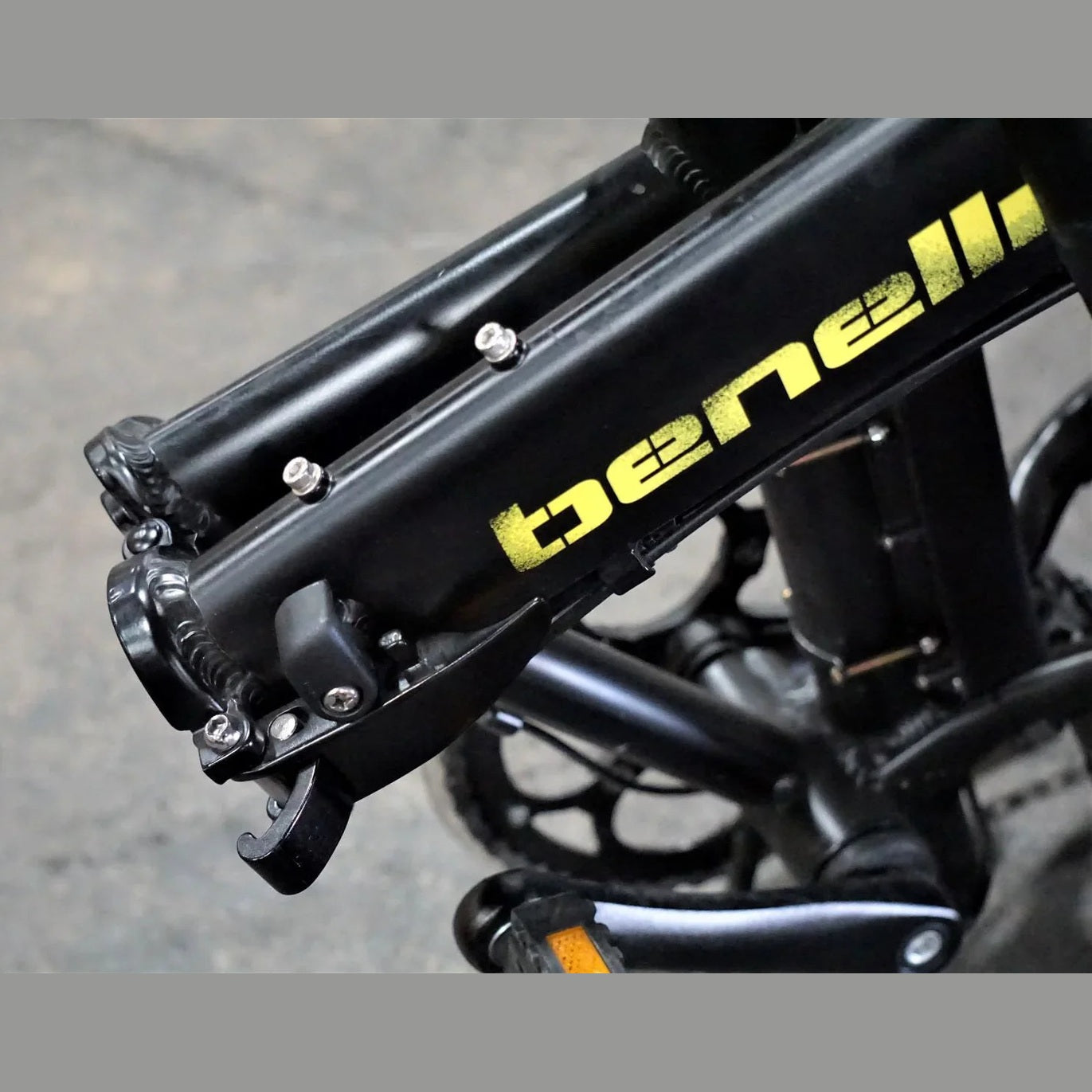 Close-up of black Benelli folding joint mechanism with metal bolts and latch