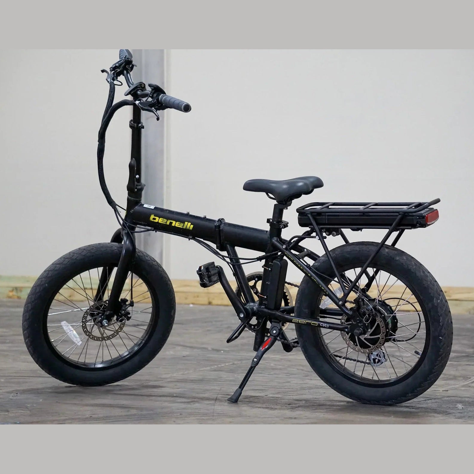 Black Benelli E-Fold 500 with thick fat tires and red reflector on concrete floor