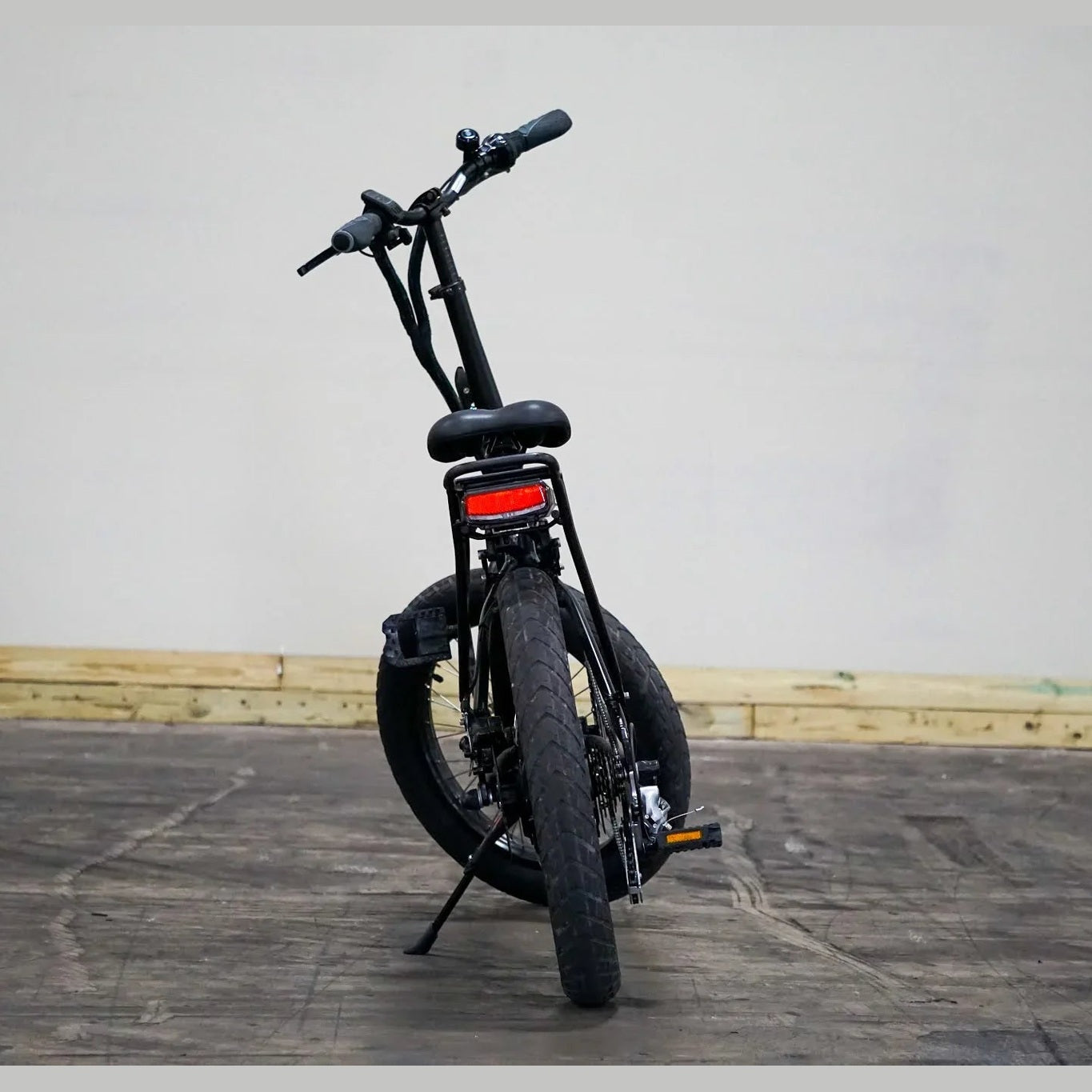 Black Benelli E-Fold 500 folding e-bike standing upright with red rear light and rack