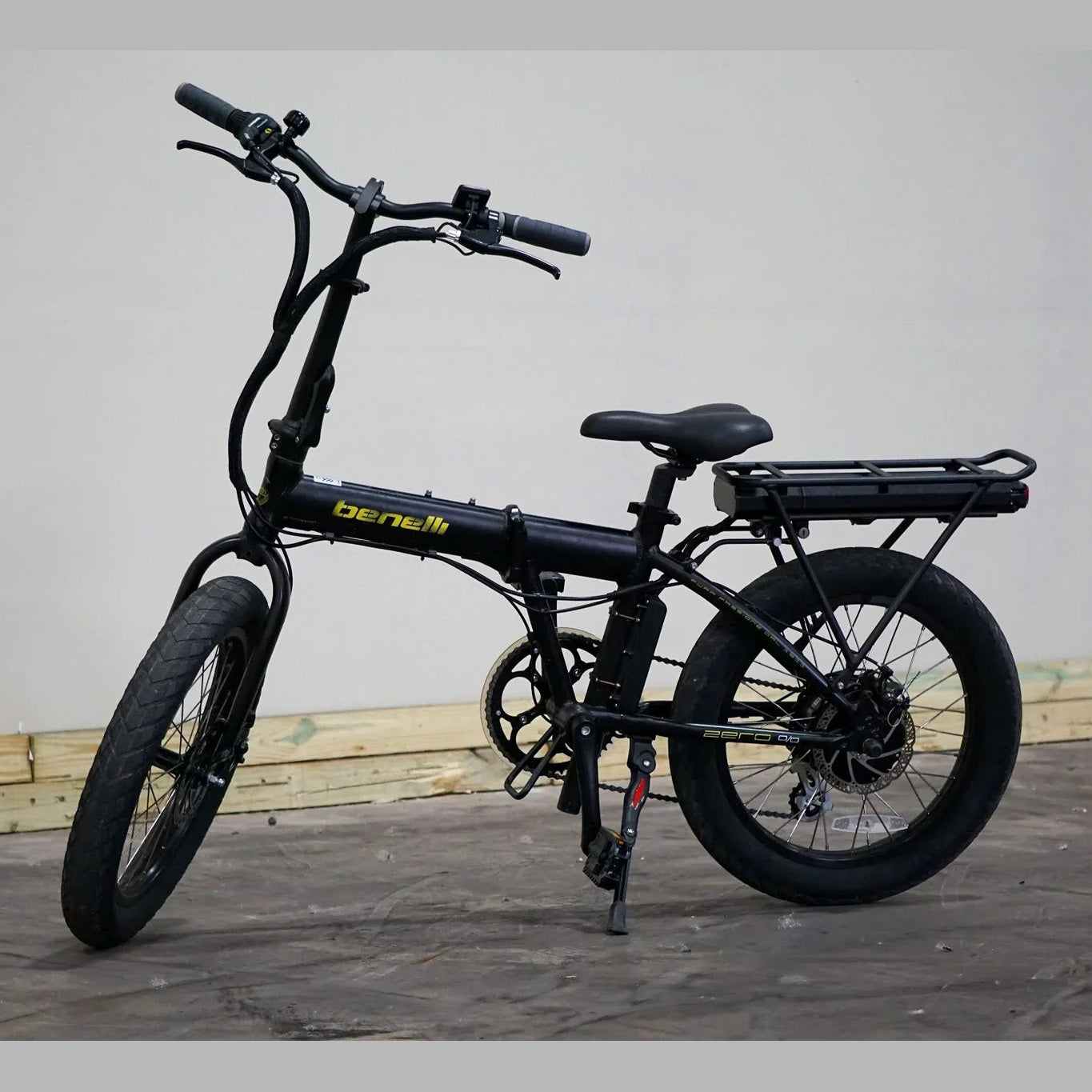 Folded black Benelli E-Fold 500 e-bike with battery pack on rear rack and disc brakes