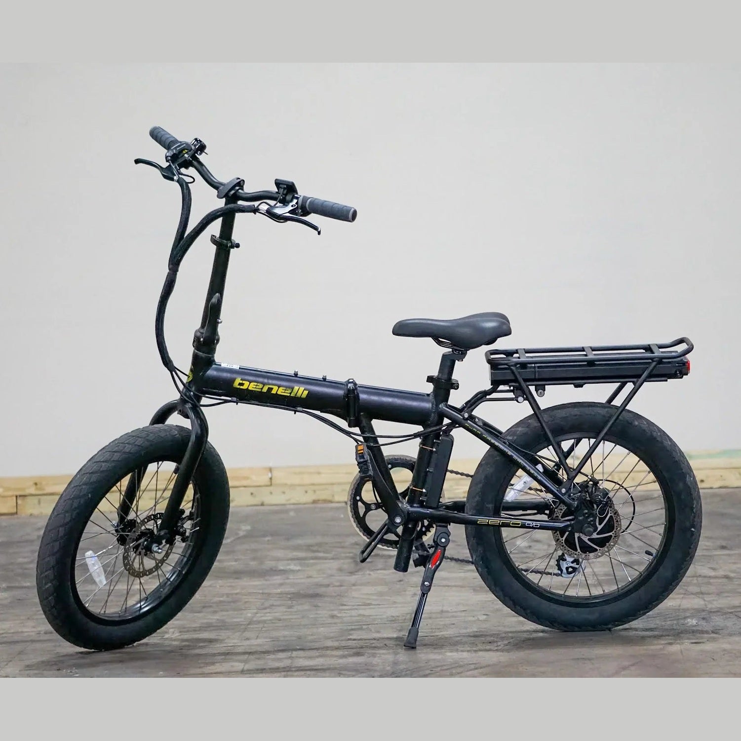 Black Benelli folding e-bike side view with extended fork and visible center hinge