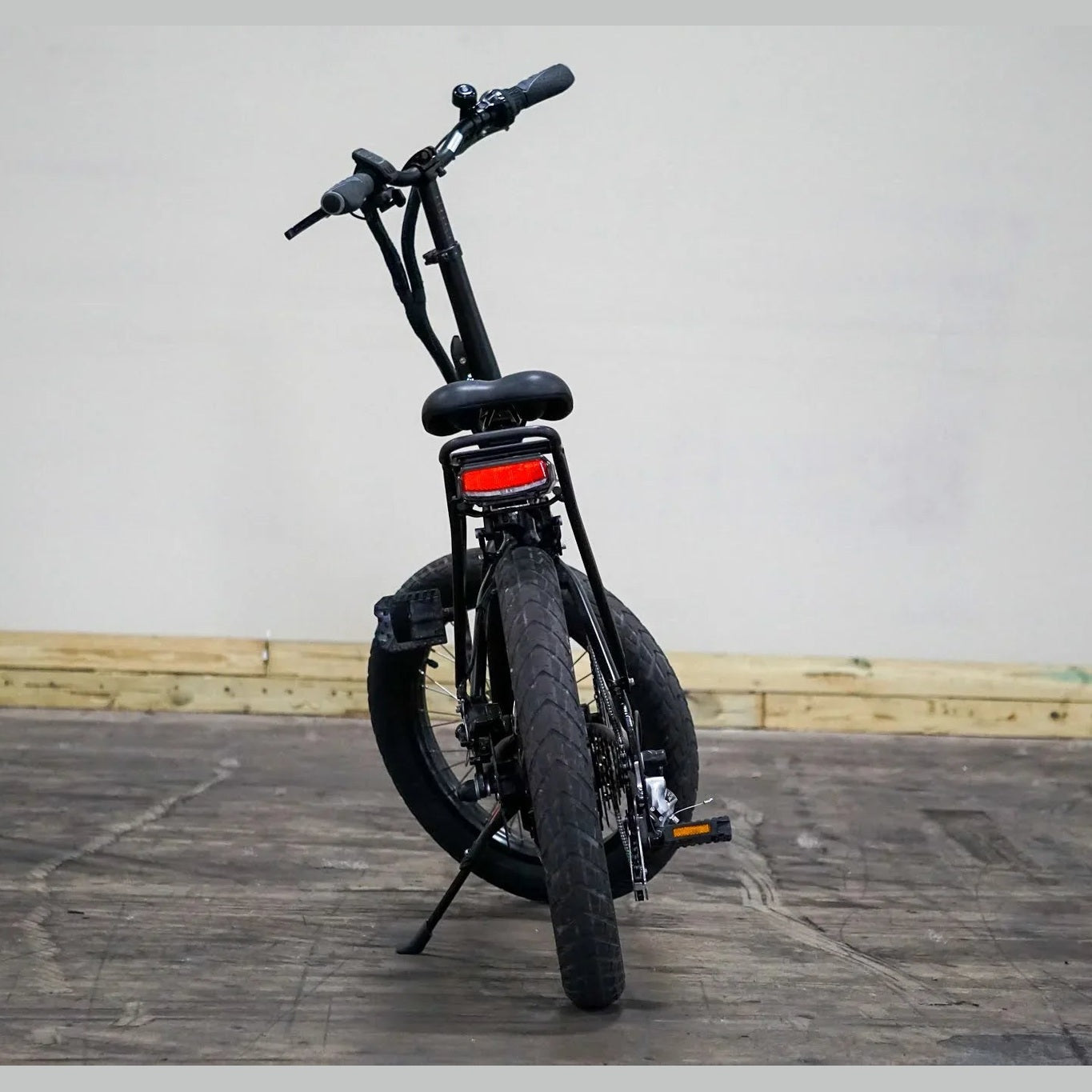 Side profile of black Benelli folding electric bike with disc brakes and cargo rack