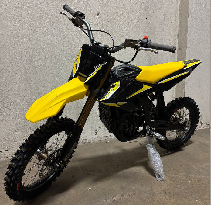 Yellow Surron Hyper Bee electric dirt bike side profile with gold forks and knobby tires