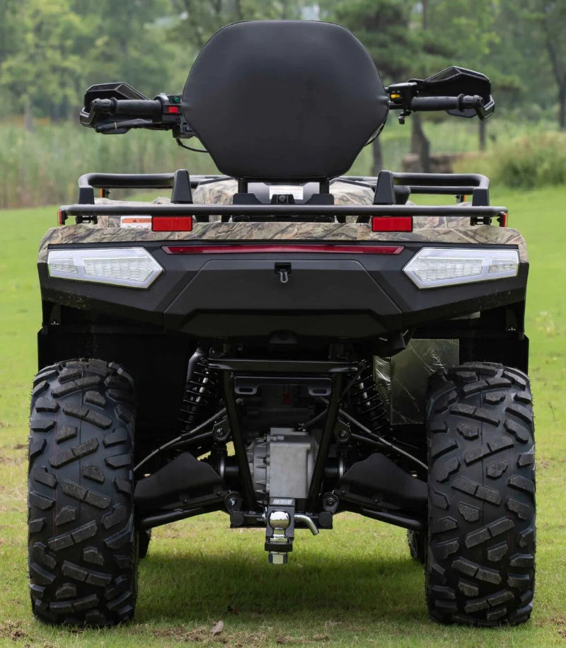Rear view of camouflage ATV with large tires, rear rack, and LED lights on grassy field