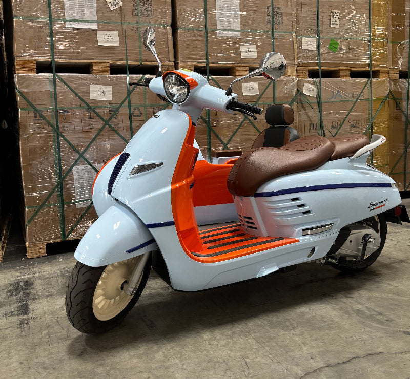 orange and white Sidecar motor scooter on the side of stack of cardboard boxes sitting on a concrete floor in turbopowersports.com warehouse