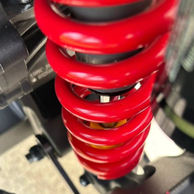 red coil rear shock absorber detail on black Atlis Sigma electric dirt bike frame