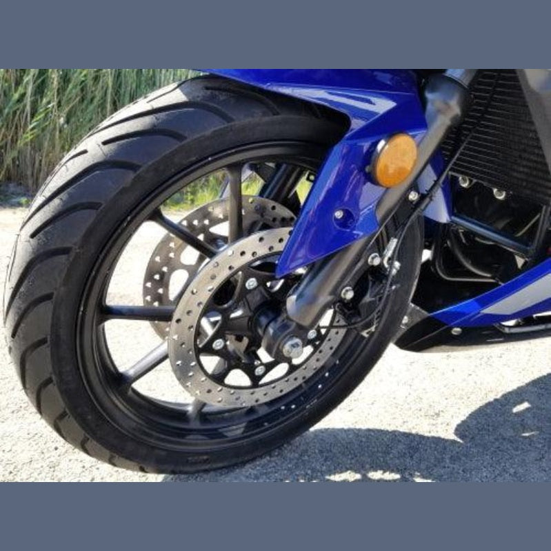Close-up of blue motorcycle front wheel with drilled disc brake and multi-spoke rim
