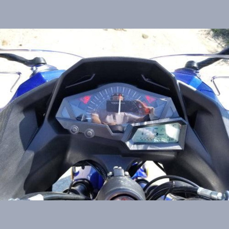 Motorcycle dashboard close-up with analog tachometer and digital speed display