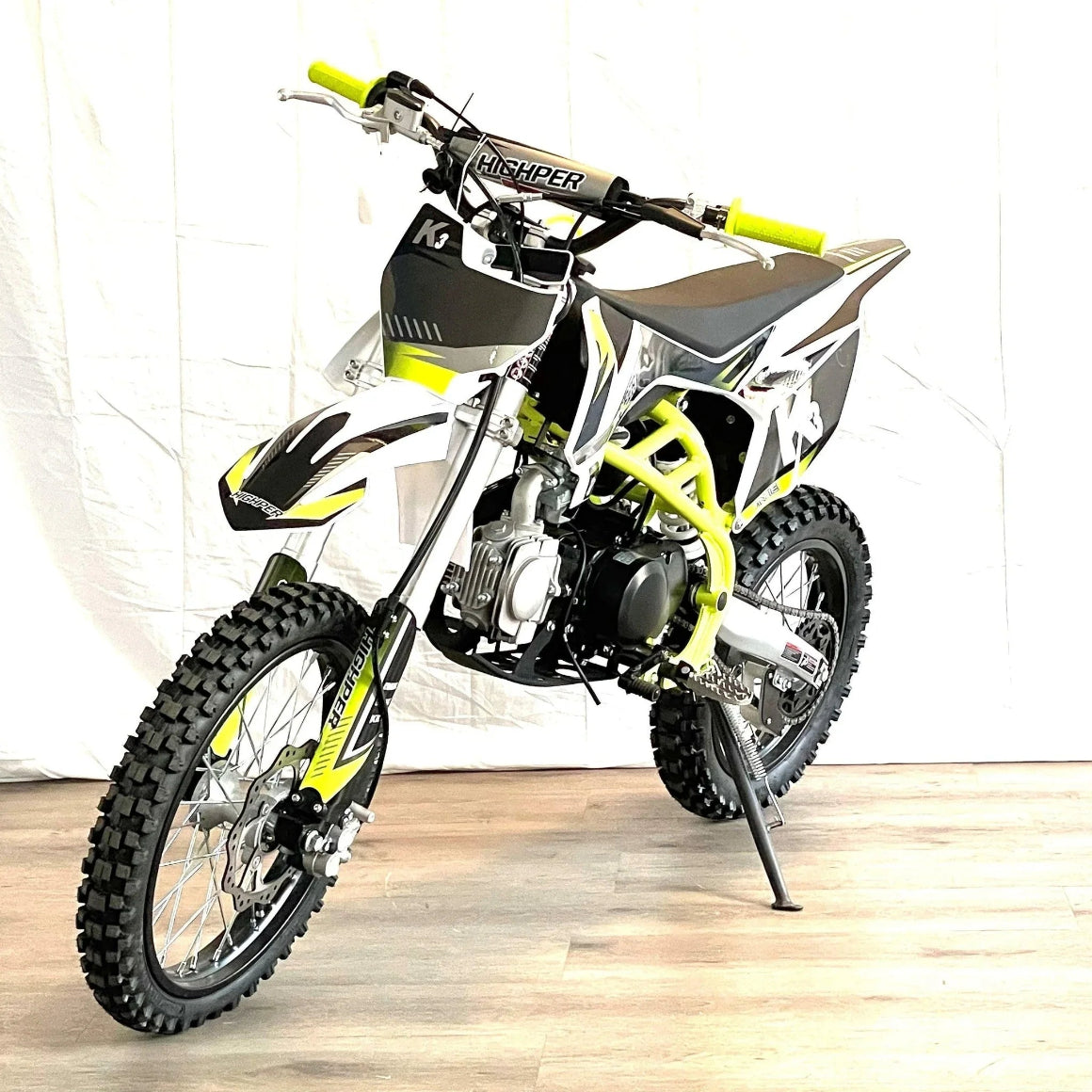 Front three-quarter view of yellow-green XTR K3 PRO 125cc dirt bike with HIGHPER graphics